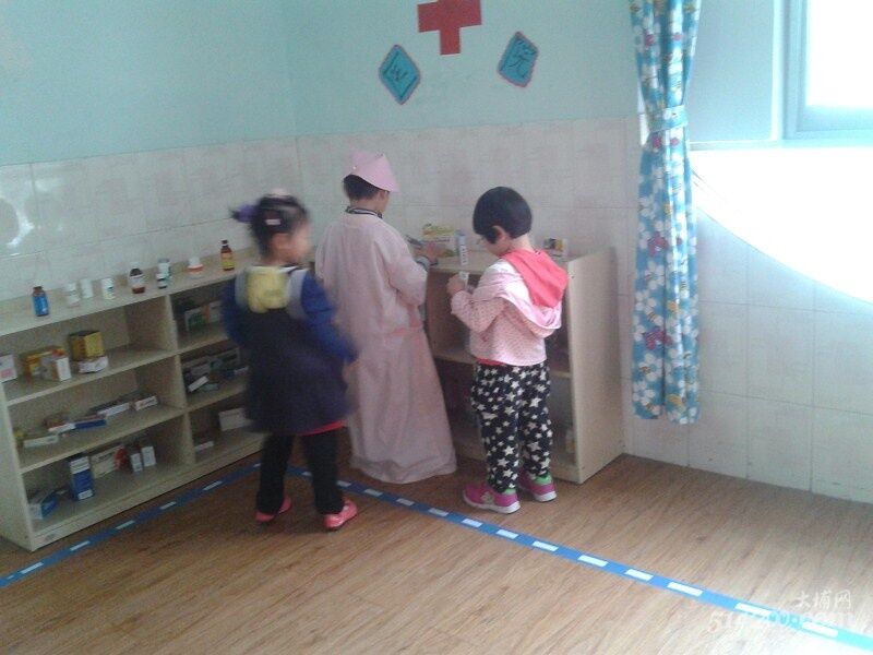 小朋友们在教室的医务区当医生、病人、护士