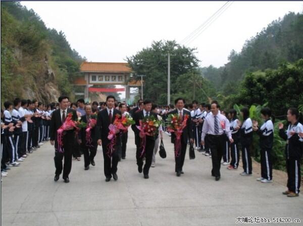 在黄广华校长陪同下,嘉宾们健步行进在欢迎队伍当中.